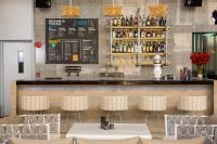 a bar with white tables and chairs in a restaurant at Bandara Suites Silom, Bangkok in Bangkok