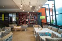 a restaurant with tables and chairs and a book shelf at Bandara Suites Silom, Bangkok in Bangkok