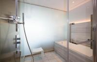 a glass shower door in a bathroom with a tub at The Prince Gallery Tokyo Kioicho, a Luxury Collection Hotel in Tokyo