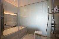 a bathroom with a shower and a tub and a chair at The Prince Gallery Tokyo Kioicho, a Luxury Collection Hotel in Tokyo