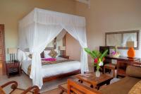 a bedroom with a bed with a canopy at Appartement à la Résidence LA PLANTATION RESORT and SPA in Saint-François