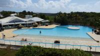 a large blue swimming pool with people in it at Appartement à la Résidence LA PLANTATION RESORT and SPA in Saint-François