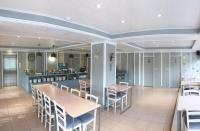 a restaurant with tables and chairs and a kitchen at Wan Tai Hotel in Chiayi City