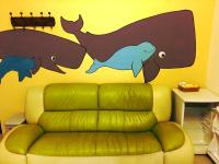 a couch with a whale and dolphins on a wall at Camellia B&amp;B in Taitung City