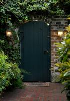 an entrance to a green door with a brick wall at Foley House Inn in Savannah