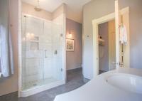 a bathroom with a tub and a glass shower at Foley House Inn in Savannah