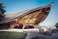 un grand pavillon en bois avec tables et chaises dans l'établissement Suarga Padang Padang, à Uluwatu