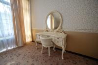 a white dressing table with a mirror on a wall at Park Hotel Borvikha in Pilichki