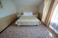 a bedroom with a bed with two night stands and a window at Park Hotel Borvikha in Pilichki