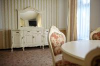 a room with a dresser with a mirror and a table at Park Hotel Borvikha in Pilichki