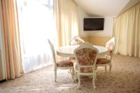 a dining room with a table and four chairs at Park Hotel Borvikha in Pilichki
