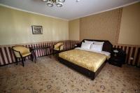 a hotel room with a bed and two chairs at Park Hotel Borvikha in Pilichki