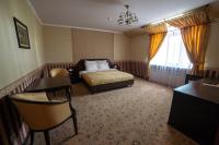 a bedroom with a bed and a chair and a window at Park Hotel Borvikha in Pilichki