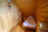 a small room with a bed in a wooden cabin at Park Hotel Borvikha in Pilichki