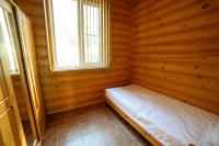 a small room with a bed in a log cabin at Park Hotel Borvikha in Pilichki