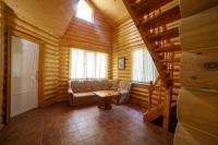 a living room with a couch in a log cabin at Park Hotel Borvikha in Pilichki