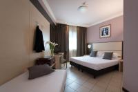 Una habitación de hotel con dos camas y un escritorio. en CDH Hotel La Spezia, en La Spezia