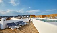 a woman walking on a balcony with chairs and a swimming pool at Delamar 4*Sup-Adults only (18+) in Lloret de Mar