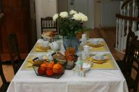 a table with a white table cloth with fruit and flowers at Les Chambres du Beau Regard in Villé