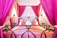 a pink bedroom with a bed with pink curtains at Alla Vite Dorata in Venice