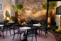 a patio with tables and chairs and a brick wall at Foley House Inn in Savannah
