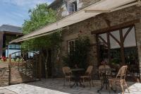 un patio avec des tables et des chaises à côté d'un bâtiment dans l'établissement Manoir de la Roche Torin, The Originals Relais, à Courtils