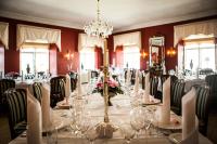 a dining room with a long table with chairs at Store Restrup Manor House in Store Restrup