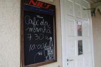 a chalkboard sign on a wall next to a door at Hotel Nils in Itapoa