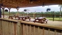 een houten terras met picknicktafels erop bij Lakewood Lodge & Restaurant in Lakewood
