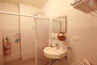a white bathroom with a sink and a shower at 5 Loaves 2 Fish B&amp;B in Hualien City