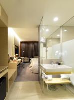 a bathroom with a sink and a room with a bed at Golden Tulip Glory Fine Hotel in Tainan