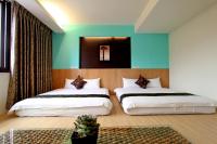 two beds in a room with blue and green walls at 開心居-正市中心電梯民宿-步行東大夜市5分鐘 in Hualien City