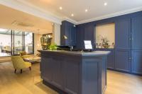 a large kitchen with blue cabinets and a sink at Jardin de Villiers in Paris