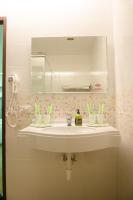a bathroom with a sink with a mirror and toothbrushes at Apple Tree Bed and Breakfast in Hualien City