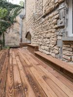 a wooden floor in front of a stone building at Appart Hôtel Bourgoin in Bourgoin
