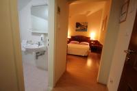 ein Badezimmer mit Waschbecken und ein Bett in einem Zimmer in der Unterkunft Villa Koruna - Mali Ston in Ston