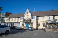 クリシャンスタードにあるHotel Bishops Arms Kristianstadの駐車場内時計塔のある白い大きな建物