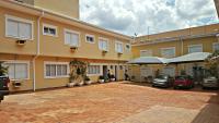 a large building with cars parked in a parking lot at Hotel Vila do Conde in Itu