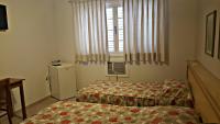 a small bedroom with a bed and a window at Hotel Vila do Conde in Itu