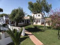 a house with a yard with a fence and trees at Hostal Las Acacias in Los Caños de Meca