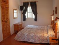 a bedroom with a bed and a dresser and a window at Hostal Las Acacias in Los Caños de Meca