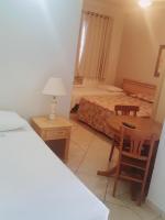 a bedroom with a bed and a desk and a table at Hotel Vila do Conde in Itu