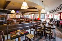 ein Restaurant mit Tischen und Stühlen und eine Bar in der Unterkunft ibis Bordeaux Lac in Bordeaux