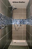 a shower in a bathroom with a tiled wall at Le Bellevue Honfleur in Honfleur