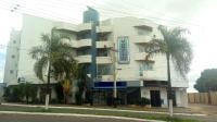 Un edificio blanco con palmeras delante. en Hotel Mohallem, en Passos