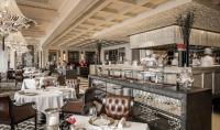 a restaurant with white tables and chairs and a bar at Four Seasons Hotel Hong Kong in Hong Kong