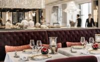 a restaurant with white tables with wine glasses at Four Seasons Hotel Hong Kong in Hong Kong