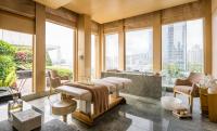 a spa room with a soaking tub and a massage table at Four Seasons Hotel Hong Kong in Hong Kong