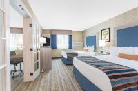 Una habitación de hotel con dos camas y un escritorio. en SilverStone Inn &amp; Suites Spokane Valley, en Spokane Valley