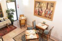 a dining room with tables and a painting on the wall at Hotel San Zulian in Venice